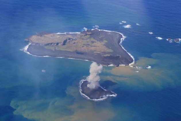 写真１。西之島と新島の噴火活動の遠景。11 月24 日昼前。 ストロンボリ式噴火を繰り返す新島。西之島と新島を南東側上空から撮影。